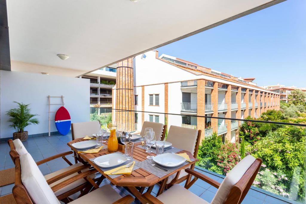 a dining room with a table and chairs on a balcony at Fábrica Lagos - Meia Praia Flat T2 in Lagos