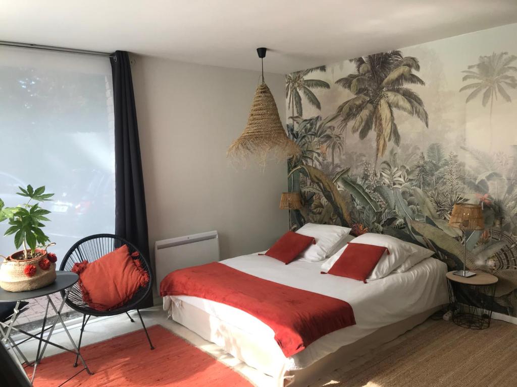 - une chambre avec un grand lit et du papier peint tropical dans l'établissement Entre Parenthèses - Lille & Villeneuve d'Ascq, à Gruson