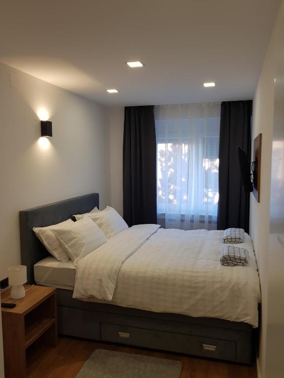 sypialnia z dużym łóżkiem i oknem w obiekcie MarSim Lux apartman Zagreb w Zagrzebiu