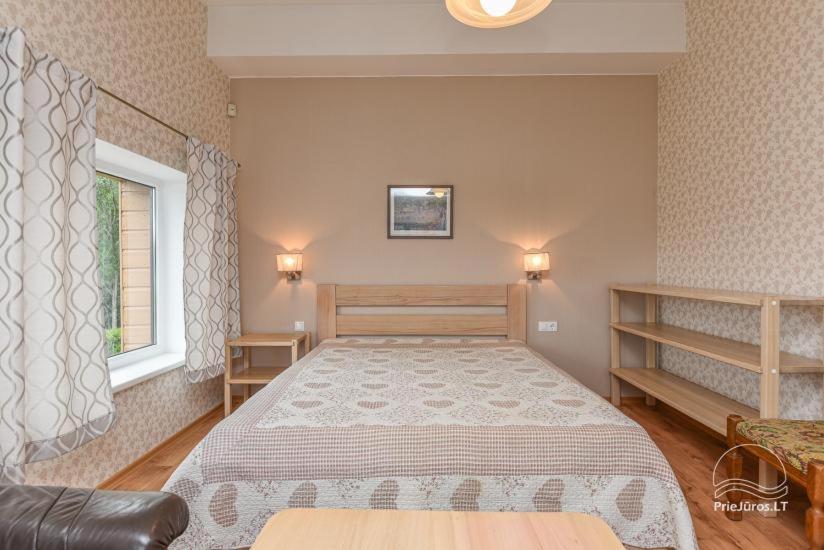 a bedroom with a large bed and a window at 7 Sakalai in Palanga