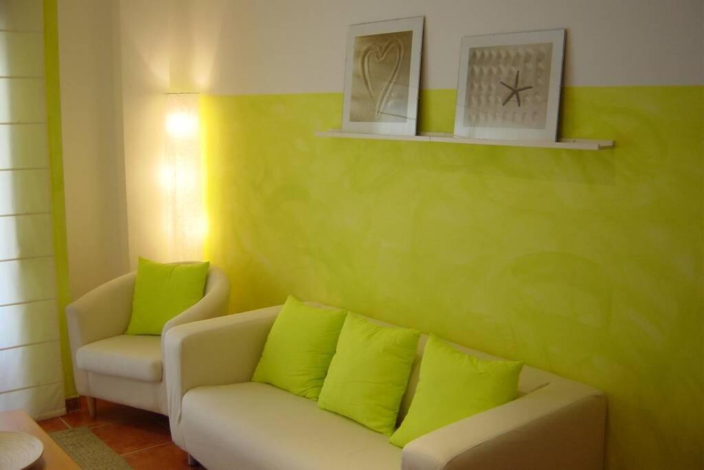 sala de estar con paredes verdes y sofá en Tresmall, en Les Cases d'Alcanar