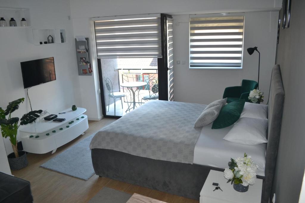 a bedroom with a bed and a balcony at Urban Apartment in Niš