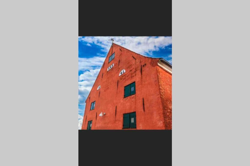 a red building with windows on the side of it at Charmerende byhus i Præstø centrum in Præstø
