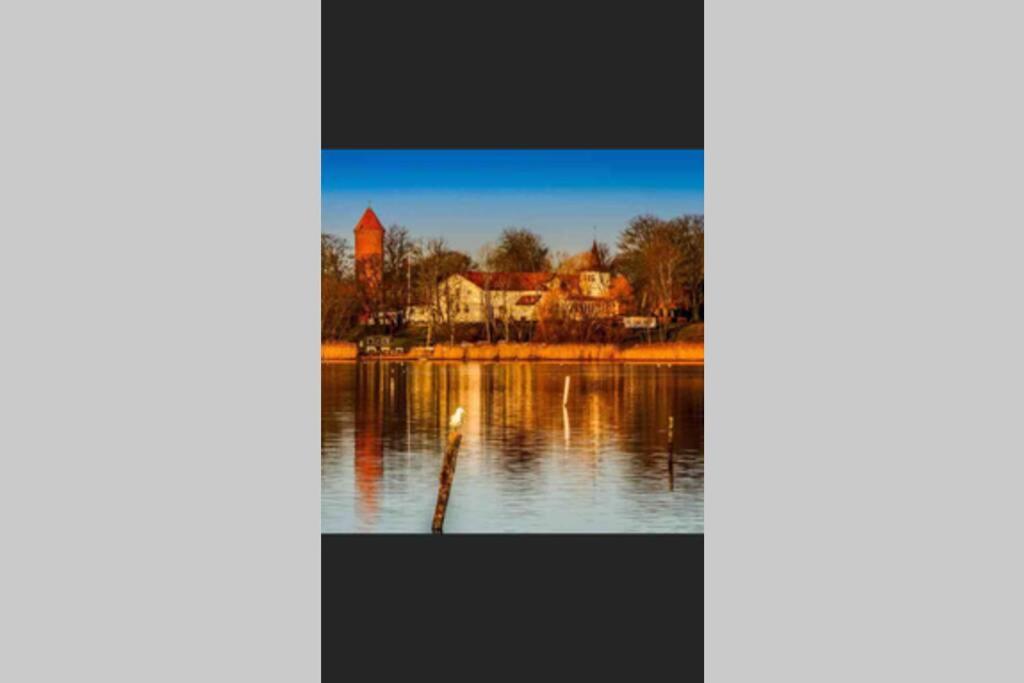 a picture of a lake with a church in the background at Charmerende byhus i Præstø centrum in Præstø