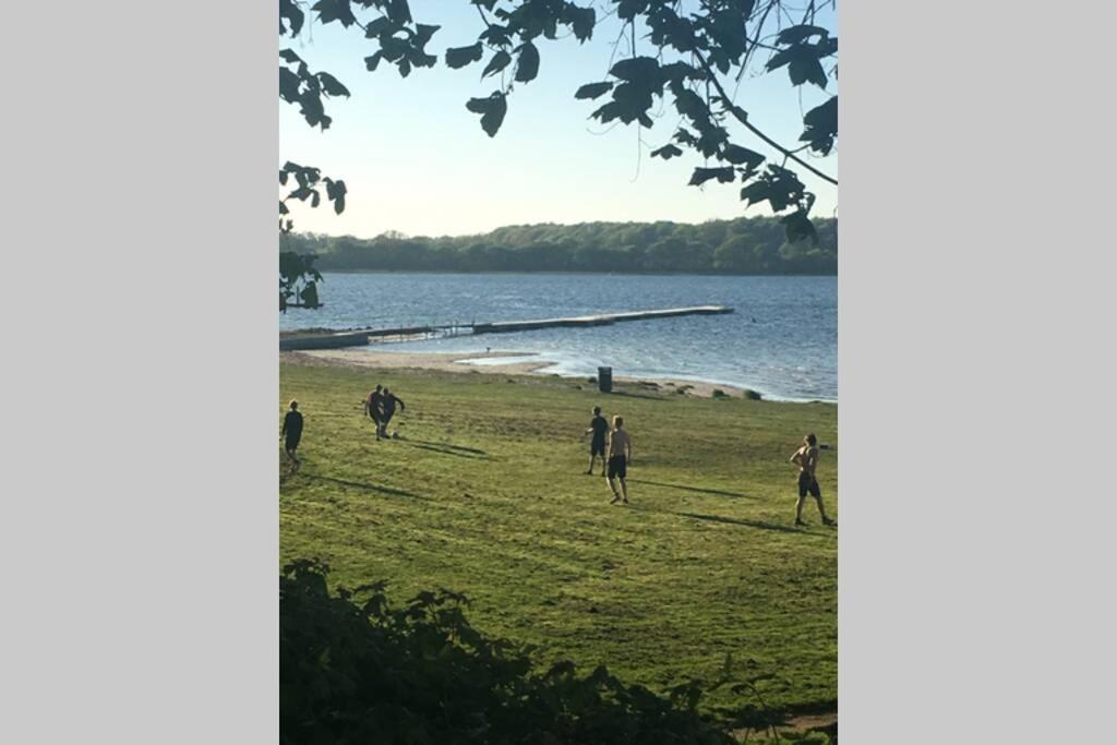 a group of people playing soccer on a field by the water at Charmerende byhus i Præstø centrum in Præstø