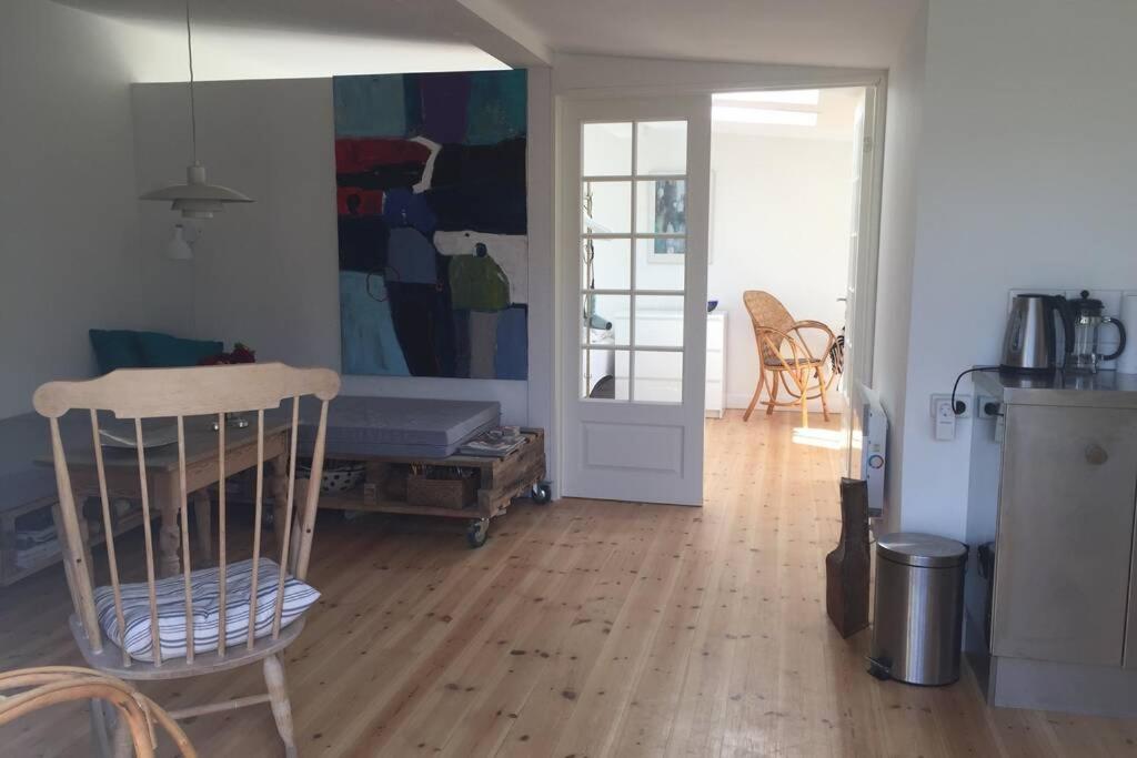 a living room with a table and a chair in it at Charmerende byhus i Præstø centrum in Præstø
