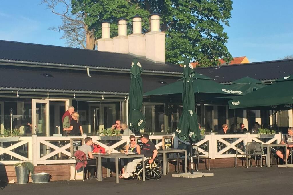 a group of people sitting at tables outside a restaurant at Charmerende byhus i Præstø centrum in Præstø