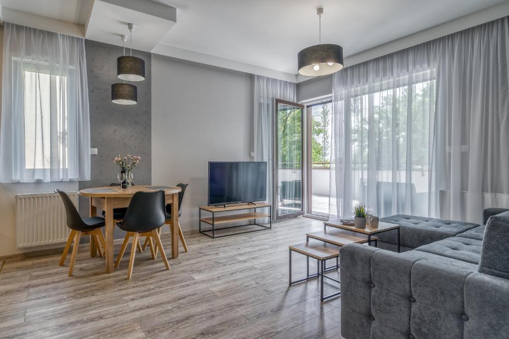 uma sala de estar com um sofá e uma mesa em Apartament K2 Pułaskiego 1 em Toruń