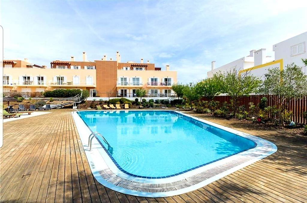 une grande piscine en face d'un bâtiment dans l'établissement T2 Cabanas Gardens piscina e praia, à Cabanas de Tavira