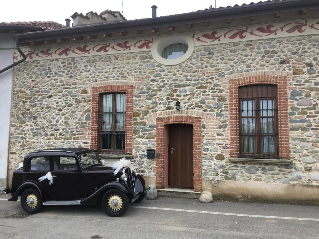 een oude zwarte auto geparkeerd buiten een stenen gebouw bij LA SACRESTIA in Mapello