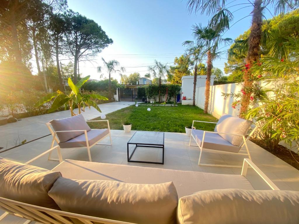een patio met 2 banken en een tafel bij White Beach Villa 1 - Luxury in Velipojë