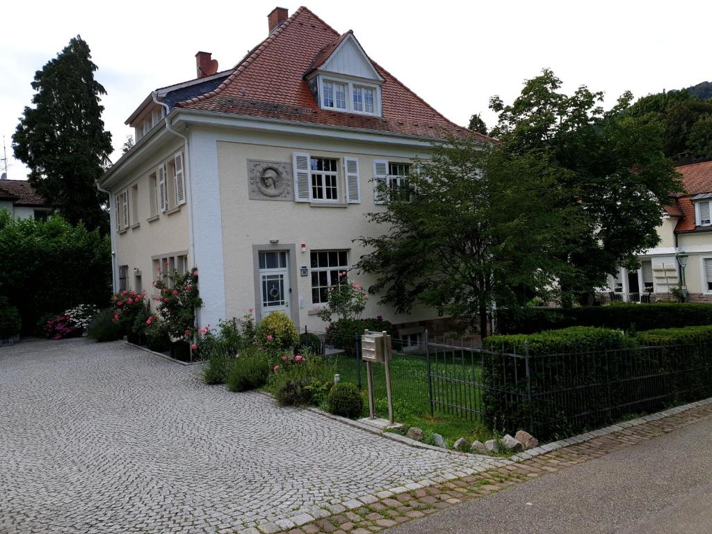 ein weißes Haus mit einer Uhr drauf in der Unterkunft Lilienmatt Apartments in Baden-Baden