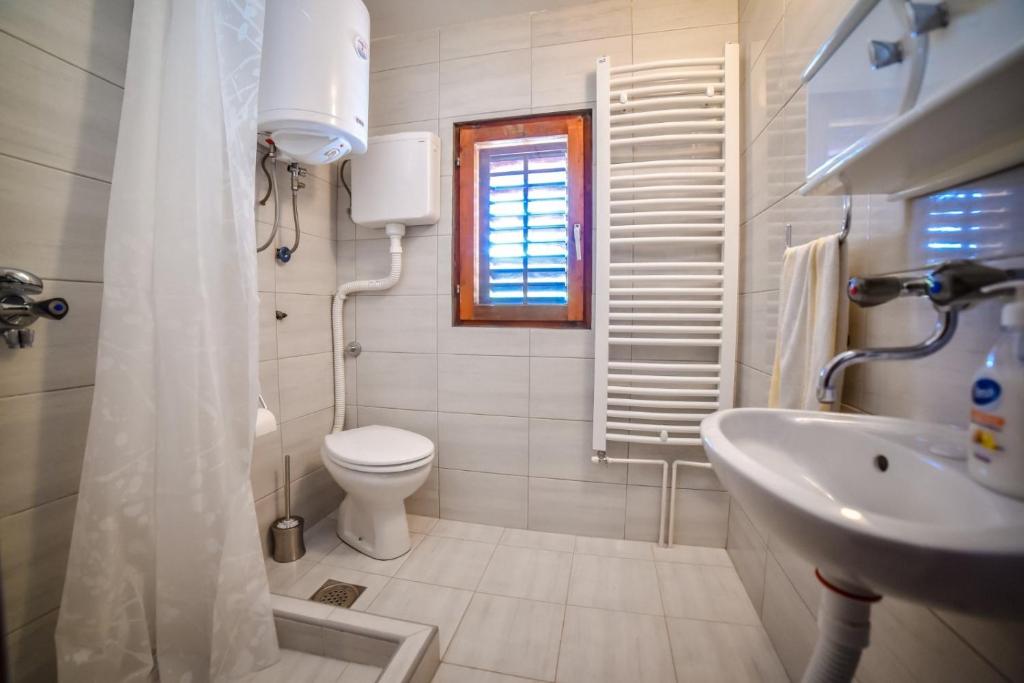 ein weißes Badezimmer mit Toilette und Waschbecken in der Unterkunft NG Apartmani Tornik Zlatibor in Zlatibor