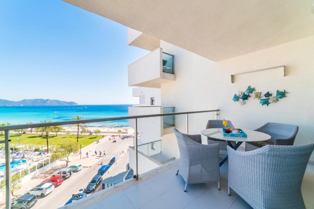 a balcony with a table and chairs and a view of the ocean at Sa Maniga 5E in Cala Millor