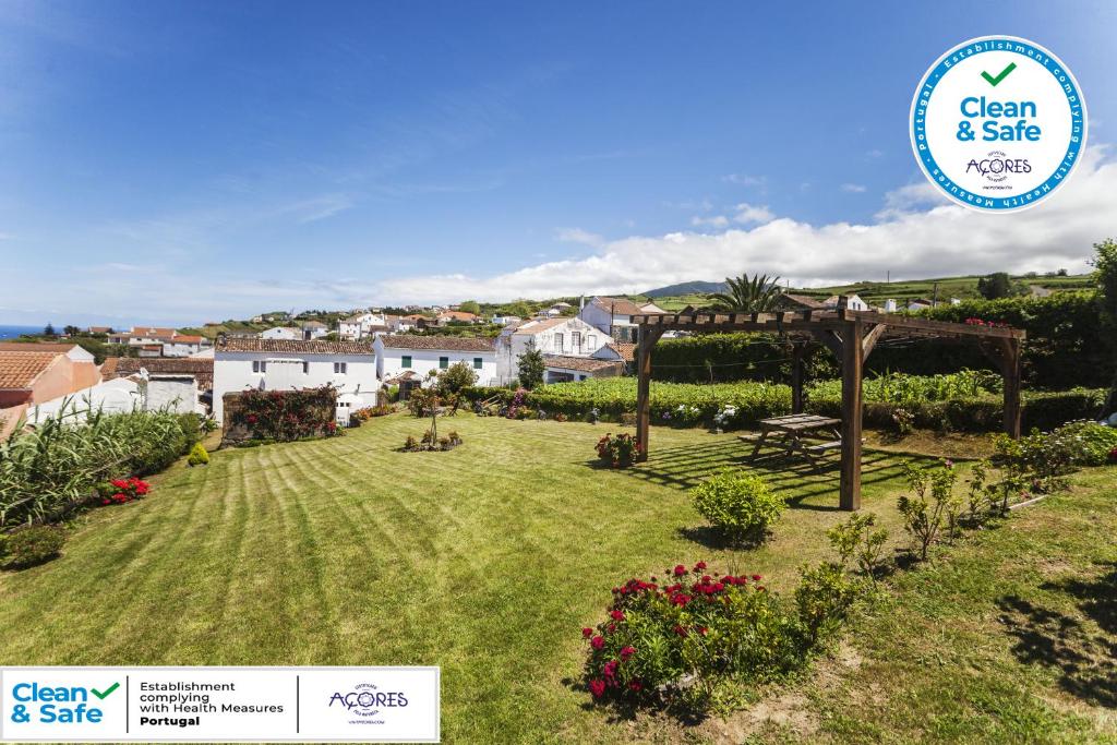 a garden with a pergola and a sign that says clean safe at Casa da Courela in Nordeste