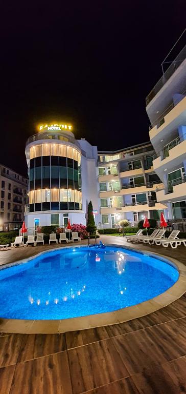 a swimming pool in front of a building at night at Favorit Aparthotel in Sunny Beach