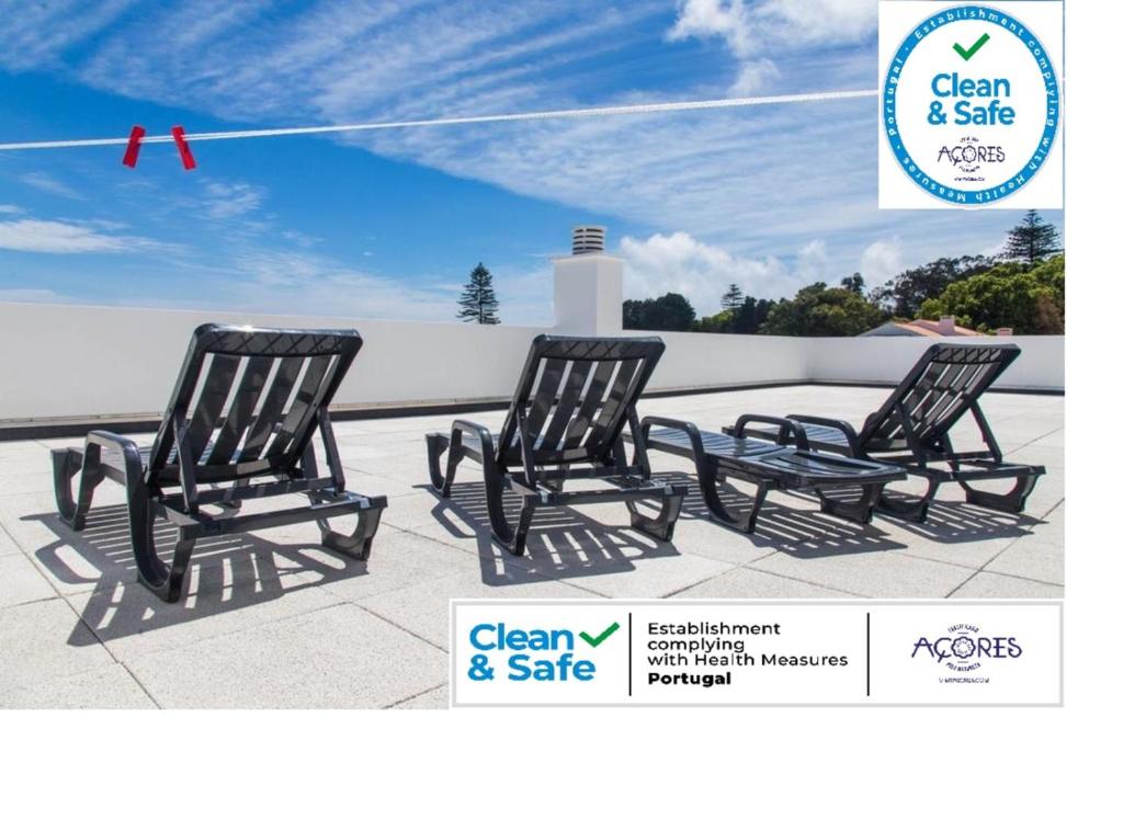 two black rocking chairs sitting on a patio at Arquinha Apartment in Ponta Delgada