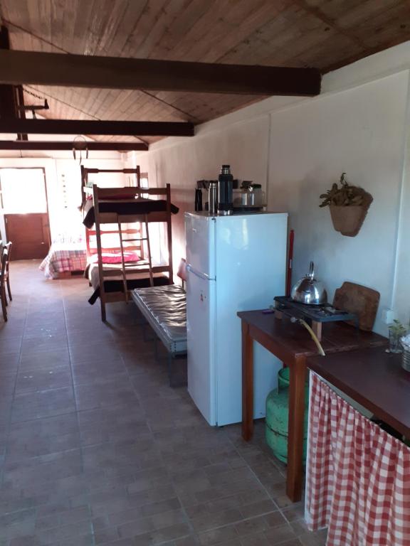a kitchen with a white refrigerator and a table at El Rancho de Chispero in Isla Patrulla