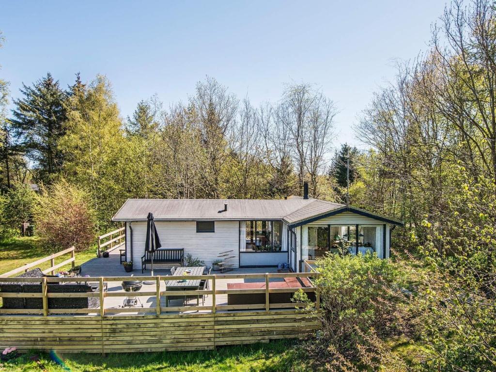 una casa pequeña con porche y terraza en 5 person holiday home in Grenaa, en Grenå