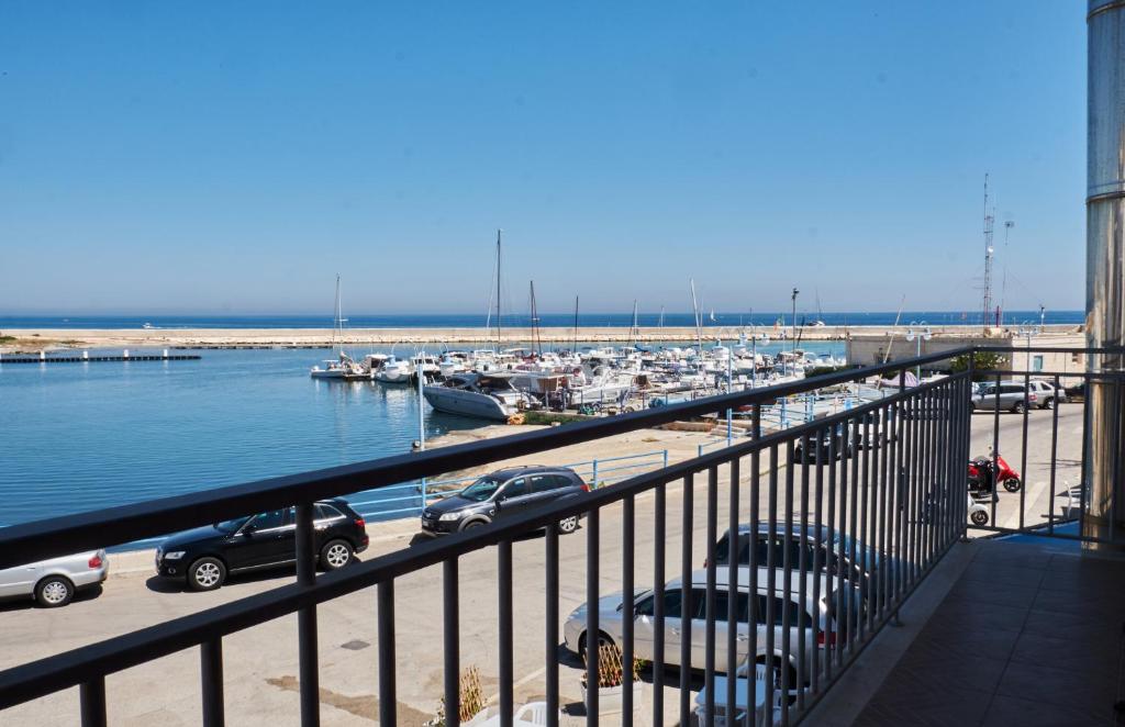 ヴィッラノーヴァ・ディ・オストゥーニにあるRed Fisherman’s House - OSTUNI Sea Frontの車とボートが停泊するマリーナの景色を望めます。