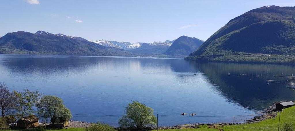 a large body of water with mountains in the background at Irenegarden - Fjord view holiday home in Lauvstad