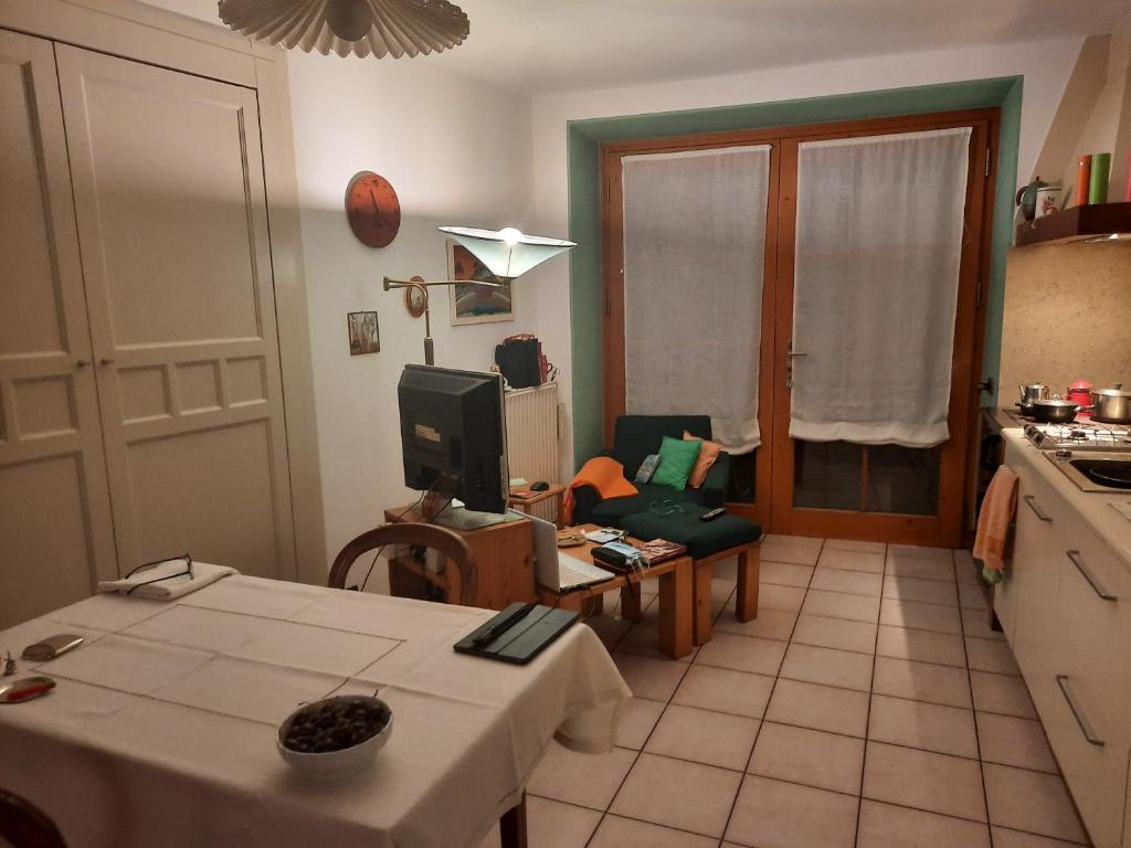 a living room with a table and a kitchen at Alla Curva di Elia Manzoni in Malè