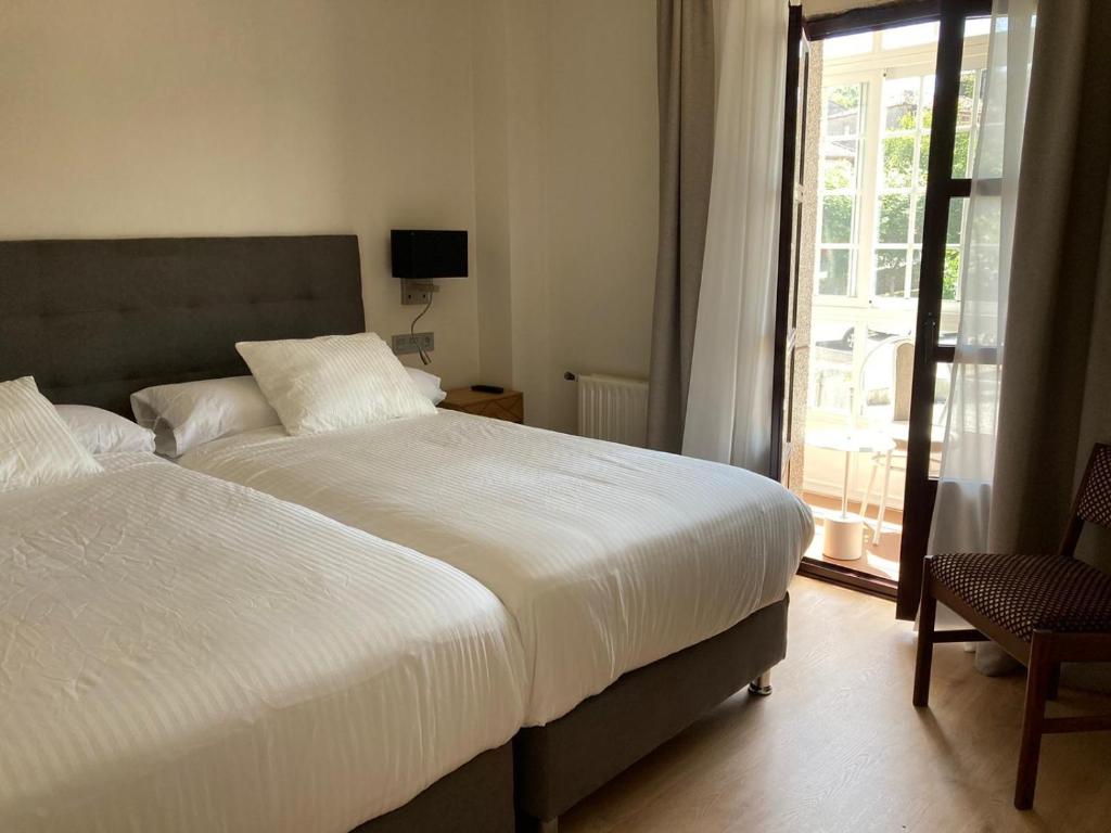 a bedroom with two beds and a window at Hotel San Marcus in Porta