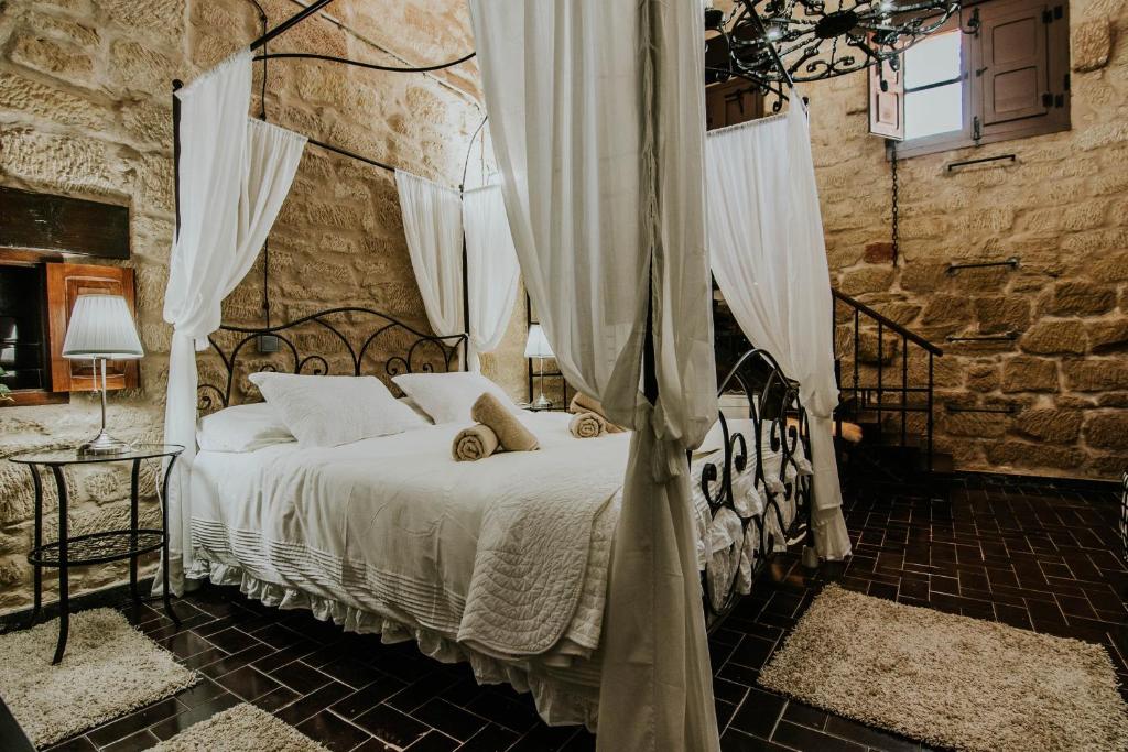 Durmiendo como Reyes en la Rioja في Cihuri: غرفة نوم بسرير في جدار حجري