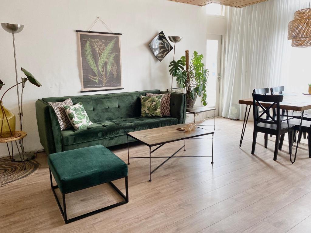 een woonkamer met een groene bank en een tafel bij Apartment Kerkplein 7A in Zandvoort