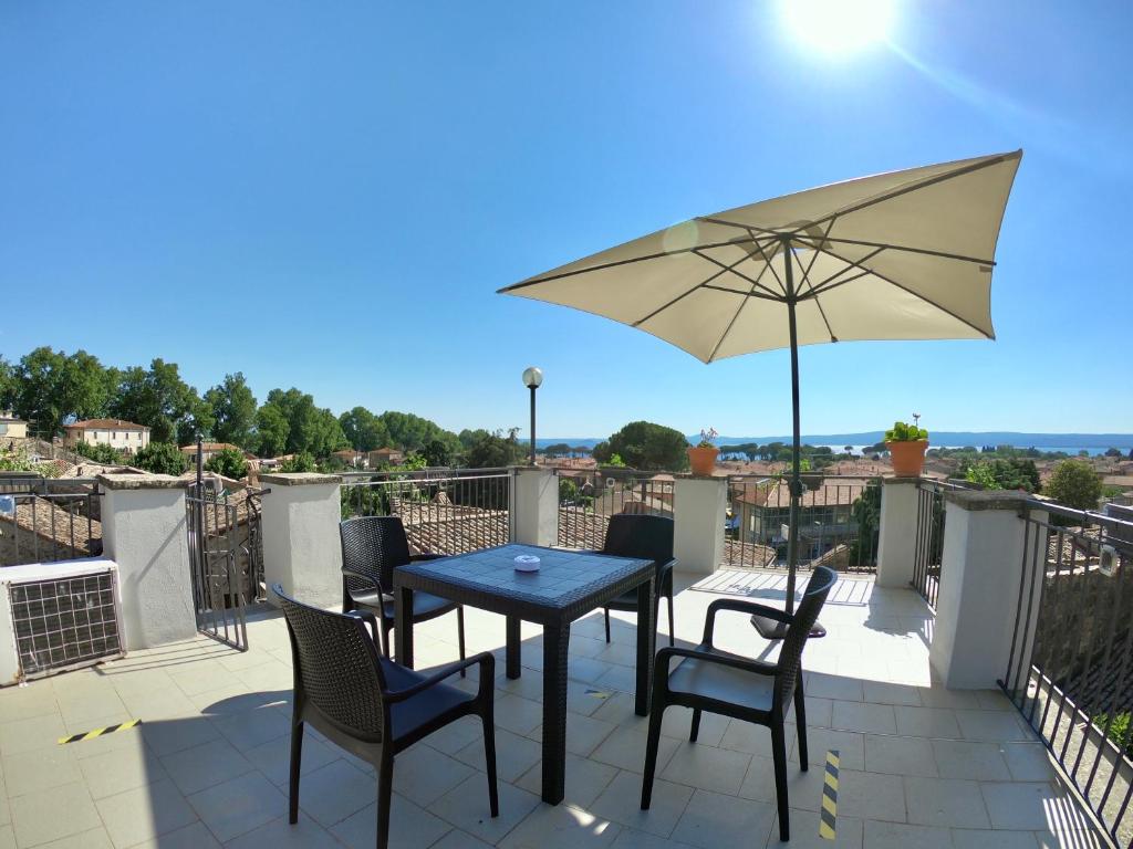 a patio with a table and chairs and an umbrella at PENSIONE ITALIA in Bolsena