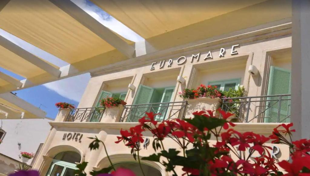 un edificio con flores frente a un balcón en Hotel Euromare, en Castro di Lecce