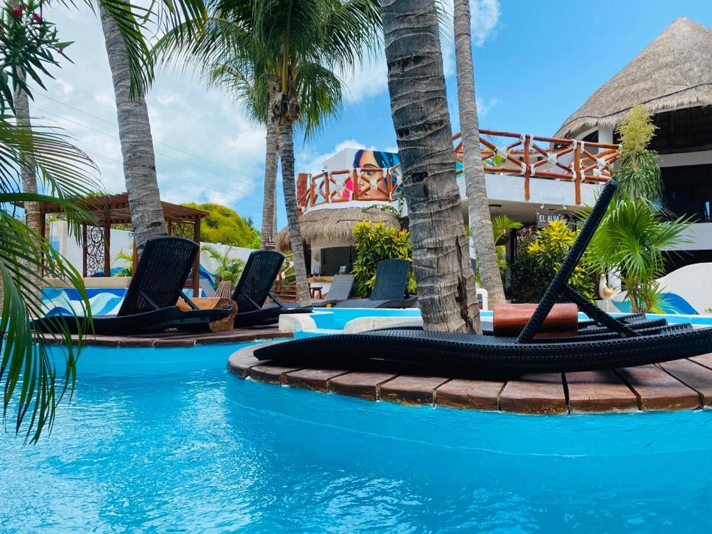 a beach with a pool, chairs, and a pool table at Hotel Para Ti - Adults Only in Holbox Island