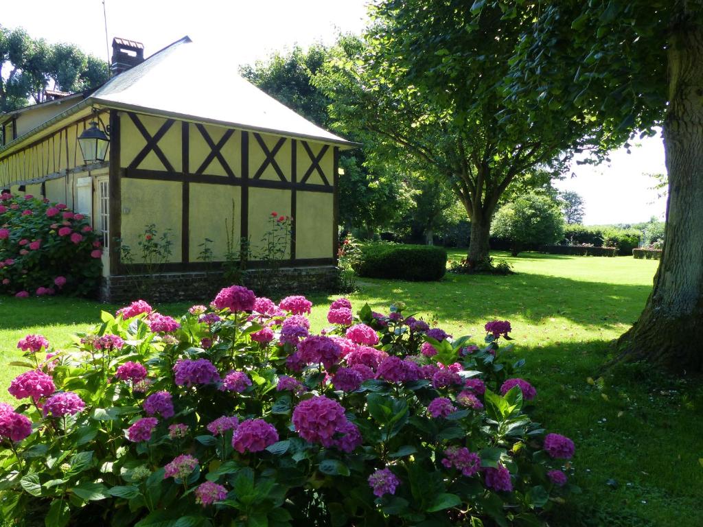 a gazebo with purple flowers in a yard at Orfea s home - maison de charme, Lyons-la-Forêt, accès direct forêt in Le Tronquay