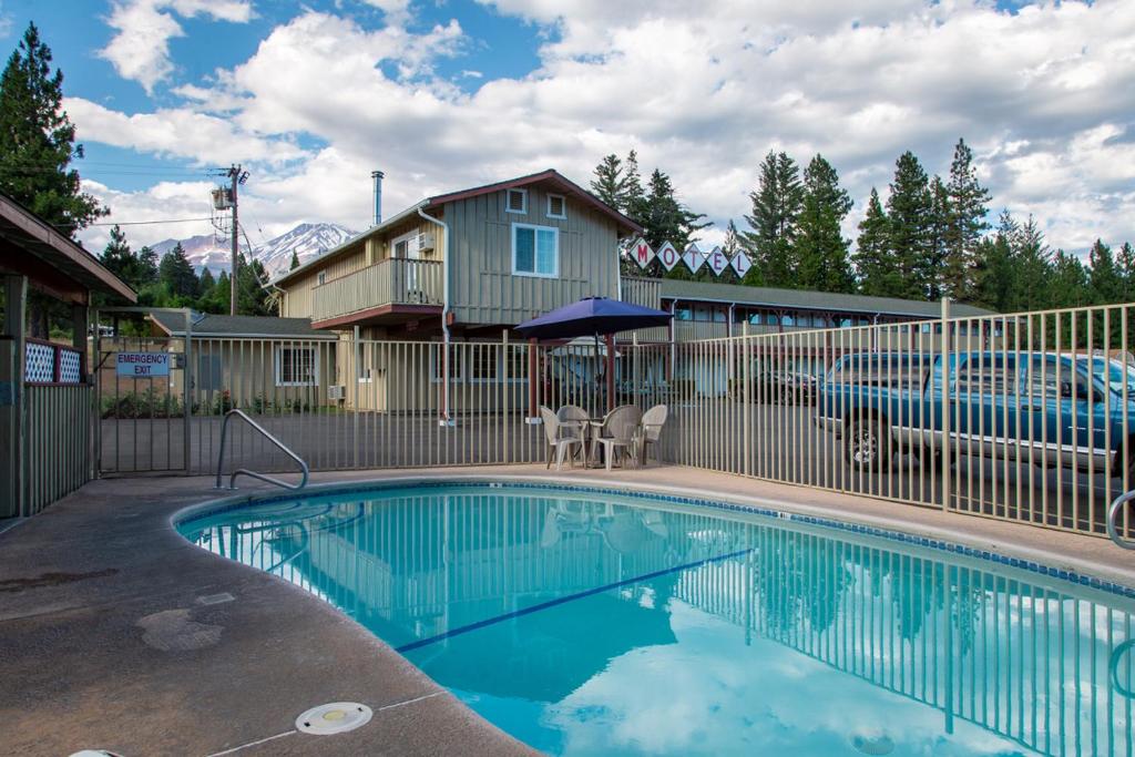 a swimming pool in front of a house at Swiss Holiday Lodge in Mount Shasta
