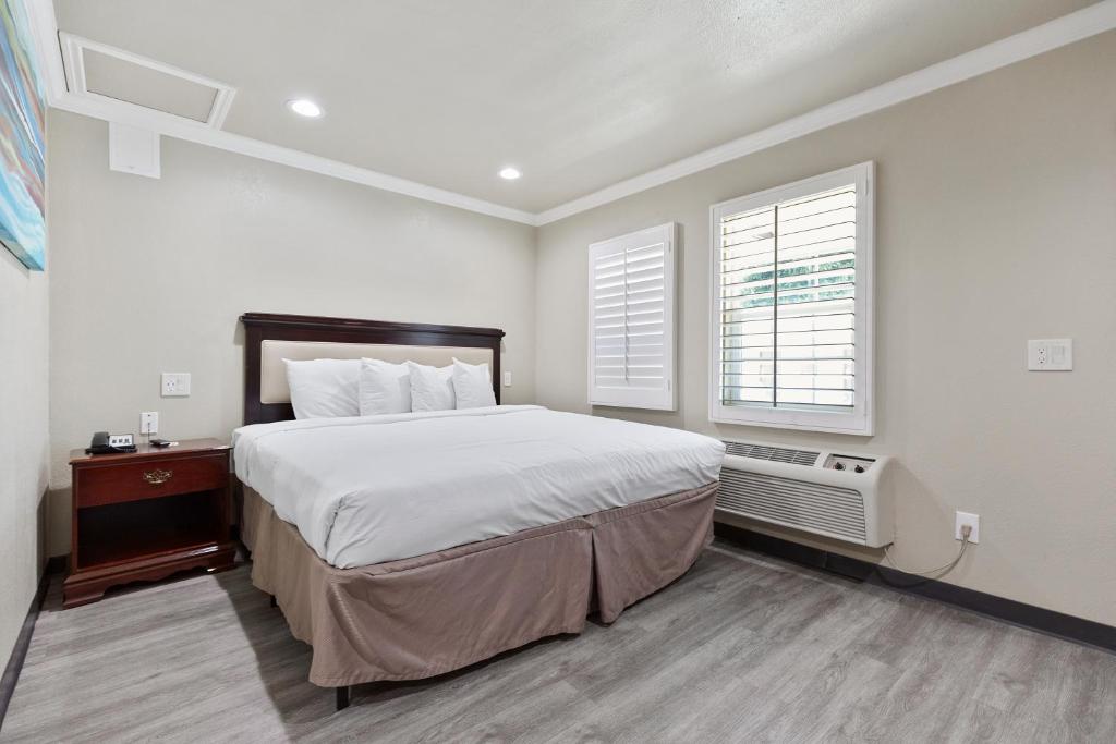 a bedroom with a large bed and a window at Le Blanc Inn & Suites in El Monte