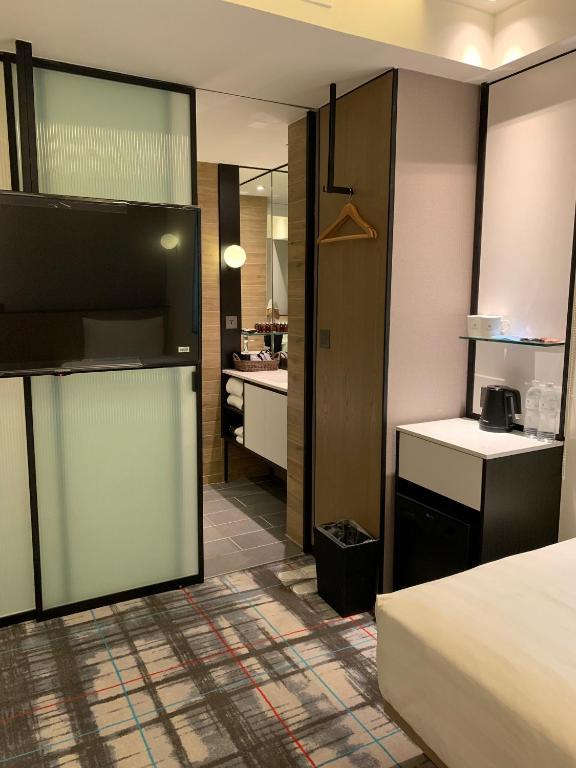 a hotel room with a bed and a bathroom at Hotel Midtown Richardson in Taipei