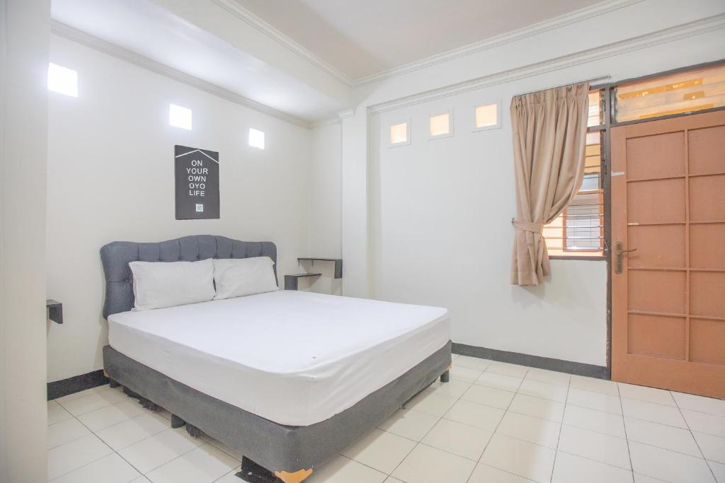 a bedroom with a bed and a window and a door at BTX 31 Residence Bintaro in Peladen
