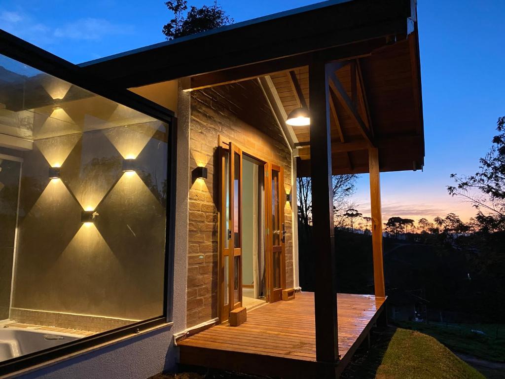 uma casa com uma porta de vidro e um deque em Villaggio da Mata em Santo Antônio do Pinhal