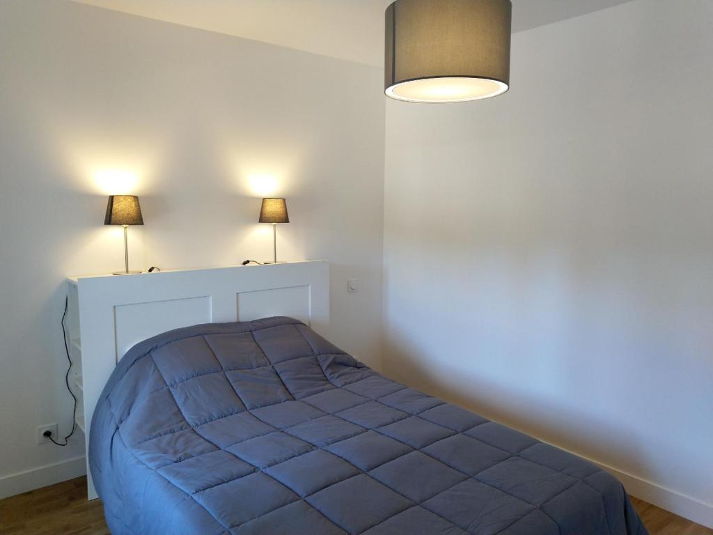 Ce lit se trouve dans un dortoir doté de 2 lampes murales. dans l'établissement La Fourmondière supérieure, maison éclusière, à Montflours