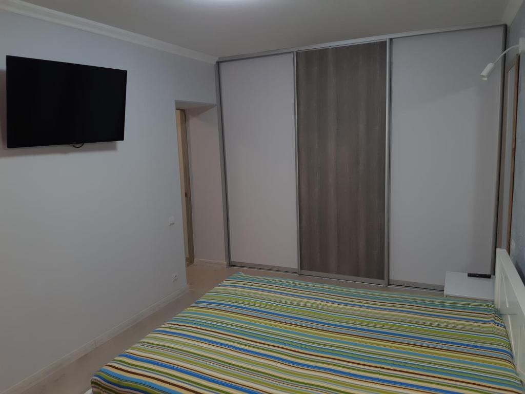 a room with a flat screen tv and a striped rug at Apartment near stadio Metalist Kharkiv in Kharkiv