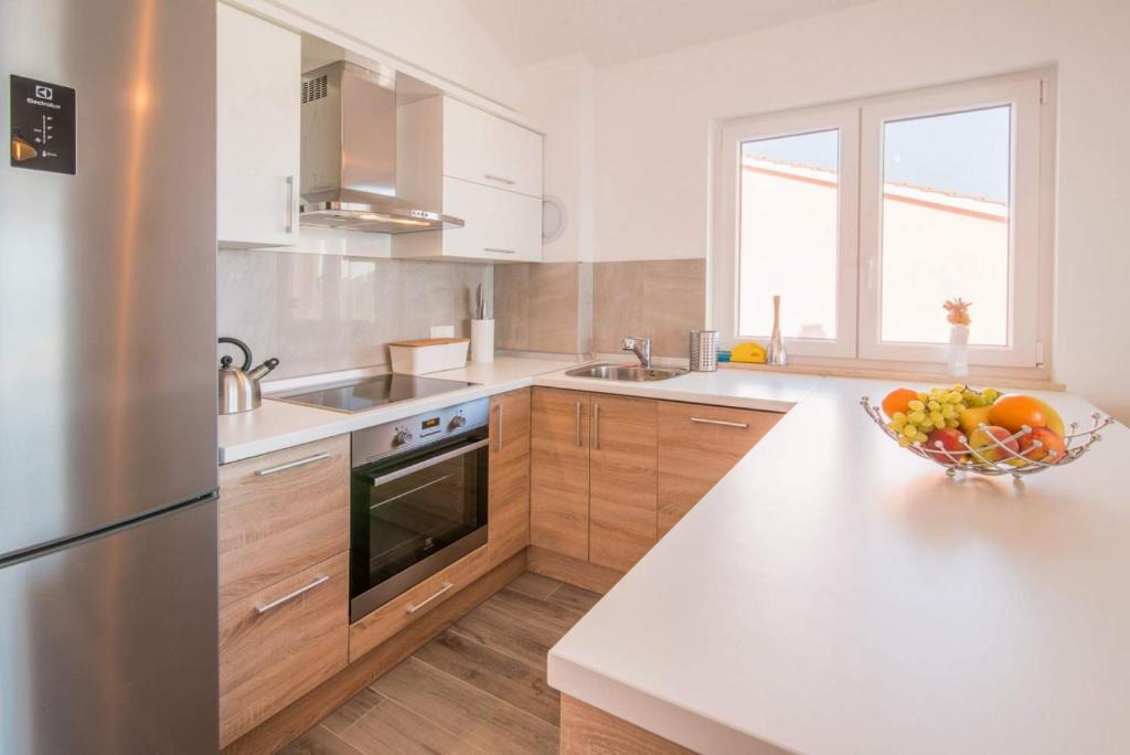 a kitchen with a bowl of fruit on a counter at Apartman Zoe Vrbnik in Vrbnik