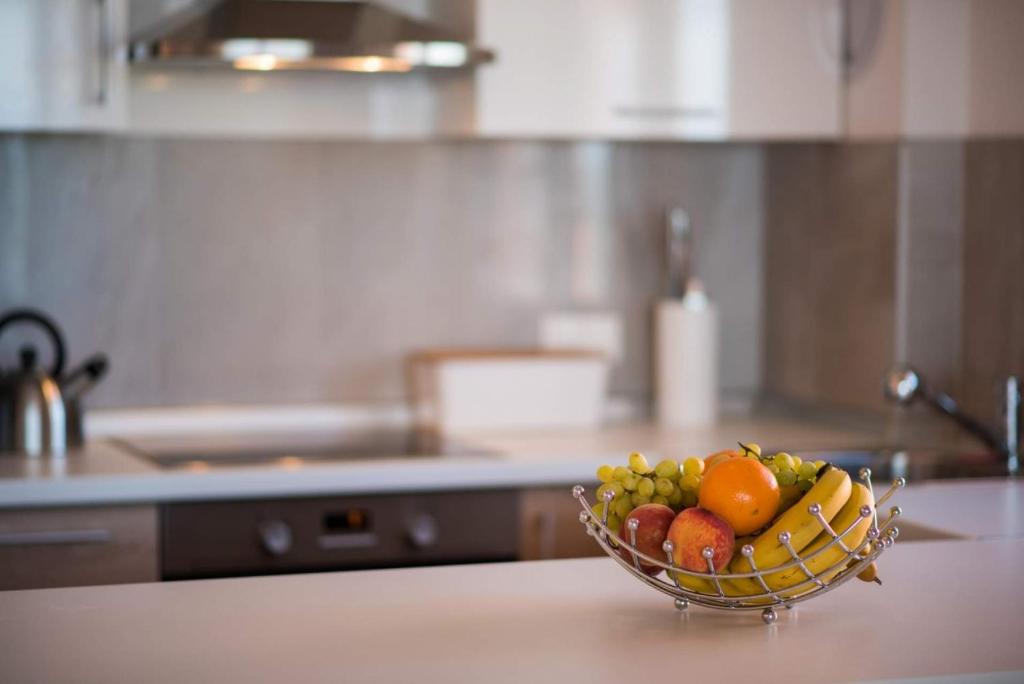 a bowl of fruit on a counter in a kitchen at Apartman Zoe Vrbnik in Vrbnik