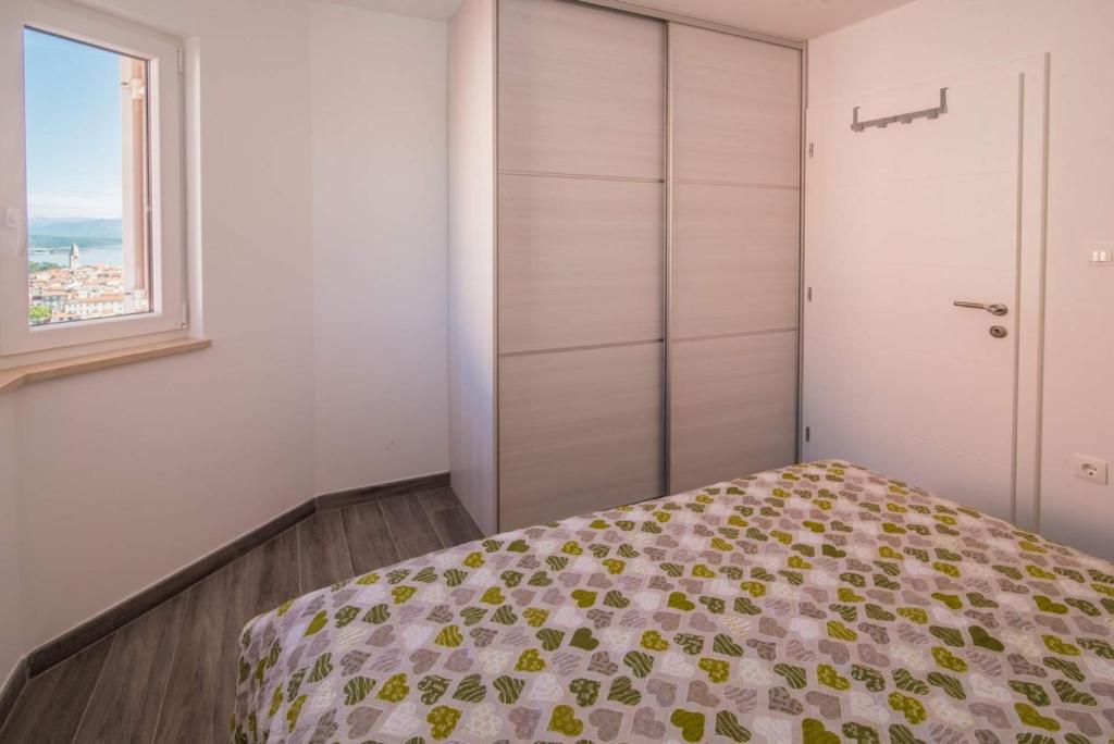 a bedroom with a bed and a window at Apartman Zoe Vrbnik in Vrbnik
