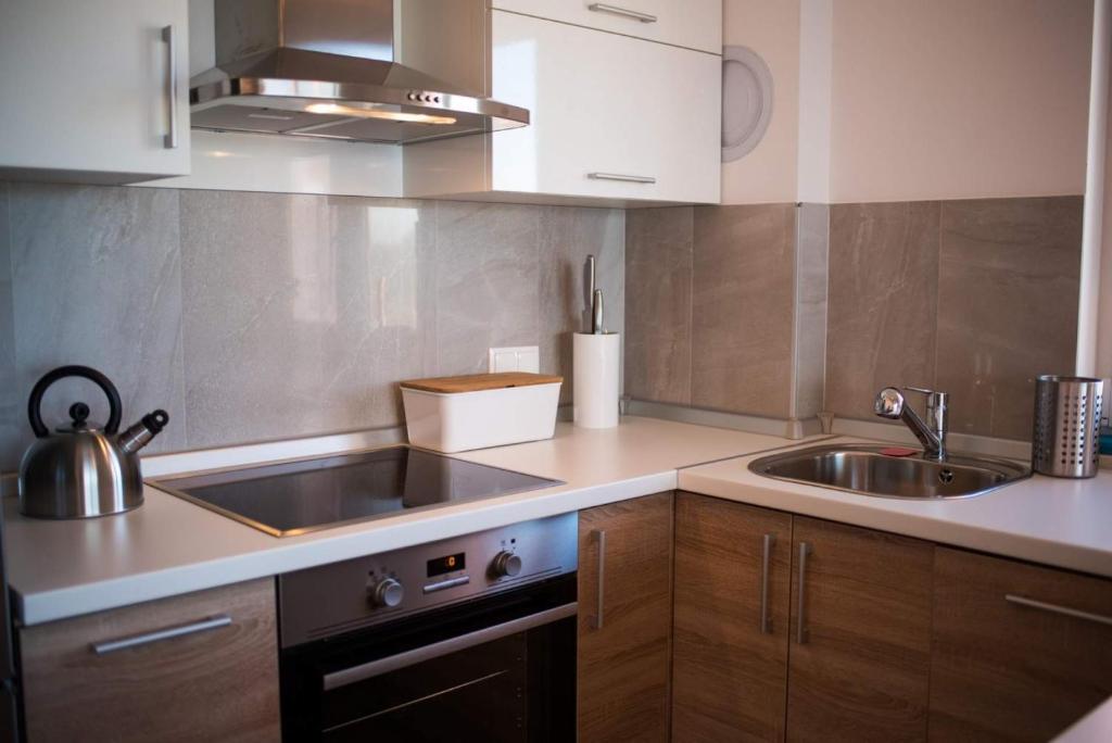 a small kitchen with a sink and a stove at Apartman Zoe Vrbnik in Vrbnik