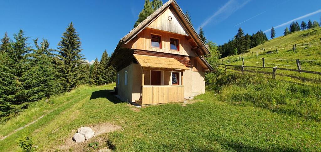 een klein huis aan de zijkant van een heuvel bij Prbajtnjeko in Bohinj