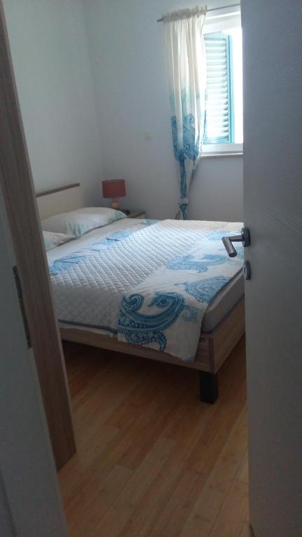 a bedroom with a bed and a window at Apartman Dalmatino in Sutivan