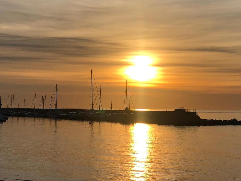 a sunset over a dock with boats in the water at Barceloneta Ramblas Apartments in Barcelona