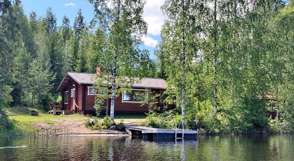 une cabine sur la rive d'un lac dans l'établissement Lomavouti Cottages, à Savonranta