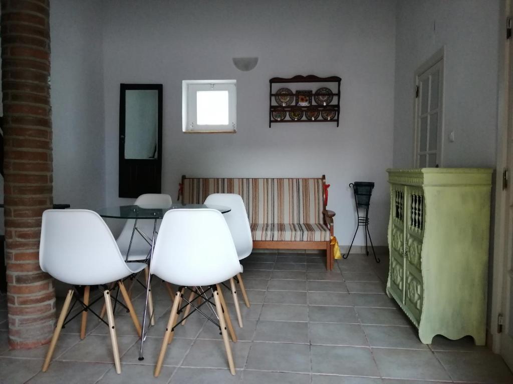 a dining room with white chairs and a table at Vitória House in Évora