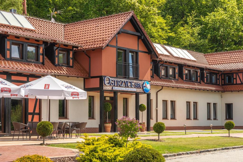 オストシツェにあるOstrzyce Spaの目の前にテーブルと椅子が置かれた建物